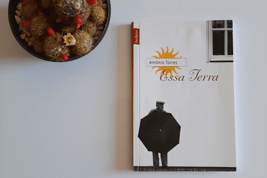 Resenha Essa Terra Antonio Torres - foto de livro e ao lado um vaso com cactos